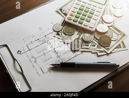 Die Investitionen für den Bau mit einem limitierten Budget, Bauplan, pen, Geld, Notebook und Rechner auf Holz- Tabelle unter Licht Stockfoto