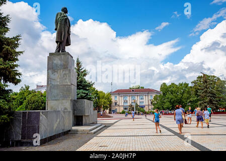 Kertsch, Russland - 5. AUGUST 2019: Unbekannter Menschen gehen neben dem Denkmal Lenin in Kertsch, Krim. Lenin war ein russischer Revolutionär, Politiker, und Stockfoto