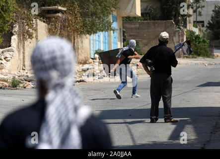 Nablus, Westjordanland, palästinensischen Gebiet. 20 Sep, 2019. Palästinensische Demonstranten tragen Reifen während der Auseinandersetzungen mit der israelischen Sicherheitskräfte verbrannt werden nach einer wöchentlichen Demonstration gegen die Enteignung des palästinensischen Landes durch Israel im Dorf Kfar Qaddum, in der Nähe der Stadt Nablus im Westjordanland am 20. September 2019 Quelle: Shadi Jarar'Ah/APA-Images/ZUMA Draht/Alamy leben Nachrichten Stockfoto