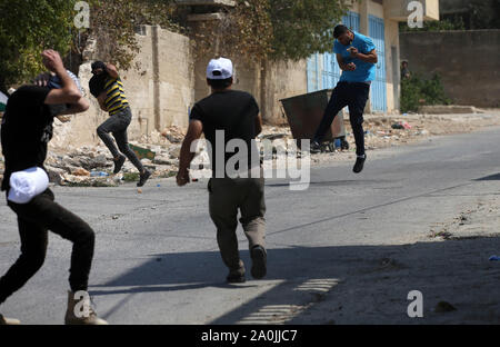 Nablus, Westjordanland, palästinensischen Gebiet. 20 Sep, 2019. Palästinensische Demonstranten tragen Reifen während der Auseinandersetzungen mit der israelischen Sicherheitskräfte verbrannt werden nach einer wöchentlichen Demonstration gegen die Enteignung des palästinensischen Landes durch Israel im Dorf Kfar Qaddum, in der Nähe der Stadt Nablus im Westjordanland am 20. September 2019 Quelle: Shadi Jarar'Ah/APA-Images/ZUMA Draht/Alamy leben Nachrichten Stockfoto