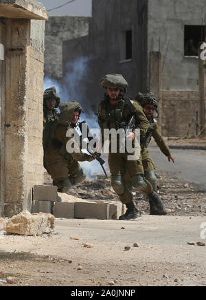 Nablus. 20 Sep, 2019. Israelische Soldaten halten ihre Waffen bei Zusammenstößen mit palästinensischen Demonstranten protestieren gegen die Ausweitung der jüdischen Siedlungen in Kufr Qadoom Dorf in der Nähe der Stadt Nablus im Westjordanland, Sept. 20, 2019. Quelle: Xinhua/Alamy leben Nachrichten Stockfoto