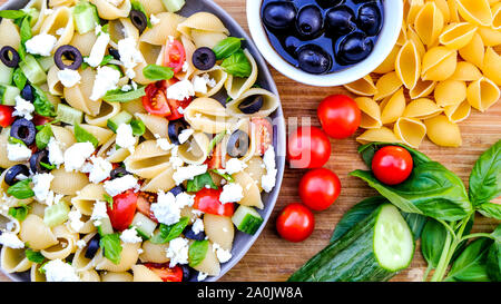 Mediterranen Stil Griechischer Nudelsalat mit Conchiglie Pasta, Tomaten, Basilikum, schwarzen Oliven und Feta Käse Stockfoto