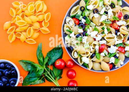 Mediterranen Stil Griechischer Nudelsalat mit Conchiglie Pasta, Tomaten, Basilikum, schwarzen Oliven und Feta Käse Stockfoto