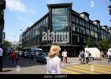 Zürich, Schweiz, 19. Juli 2019: Straße mit Fußgängern vor dem Haupteingang der Jelmoli in Zürich. an einem sonnigen Tag. Stockfoto