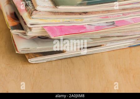 Stapel von bunten Zeitschriften auf dem Holztisch. Kopieren Sie Platz. Mockup für Design. Stockfoto