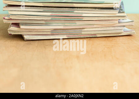 Stapel von bunten Zeitschriften auf dem Holztisch. Kopieren Sie Platz. Mockup für Design. Stockfoto