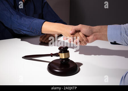 Close-up Mallet und Hammer vor Richter Händeschütteln mit seinem Client Stockfoto