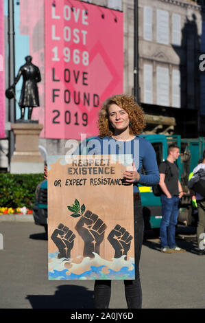 Glasgow, UK. 20. September 2019. Im Bild: Eine Klimawandel Demonstrant steht neben einem Zeichen, liest, "die Achtung der EXISTENZ ODER WIDERSTAND". Wird es etwas für unsere zukünftige Generationen hinterlassen werden? Szenen aus einem geplanten Protest auf dem George Square am Nachmittag nach Streiks begann vor einem Jahr die 16-jährige Schwedische Schulmädchen namens Greta Thunberg. Hunderte von Kreide markiert Slogans der Beton der George Square mit Demonstranten aus allen Alters und aller Hintergründe übersät. Credit: Colin Fisher/Alamy leben Nachrichten Stockfoto