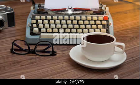 Schreibmaschine Auf der alten hölzernen Schreibtisch mit Kaffeetasse, Schriftsteller block Büro Schreibtisch Stockfoto