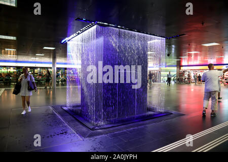 Zürich, Schweiz, 19. Juli 2019: in der Nähe von farbigen Springbrunnen in der Unterführung vom Bahnhof. Innenraum der Hauptbahnhof Zürich Stockfoto