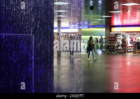 Zürich, Schweiz, 19. Juli 2019: in der Nähe von farbigen Springbrunnen in der Unterführung vom Bahnhof. Innenraum der Hauptbahnhof Zürich Stockfoto
