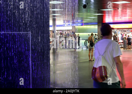 Zürich, Schweiz, 19. Juli 2019: in der Nähe von farbigen Springbrunnen in der Unterführung vom Bahnhof. Innenraum der Hauptbahnhof Zürich Stockfoto