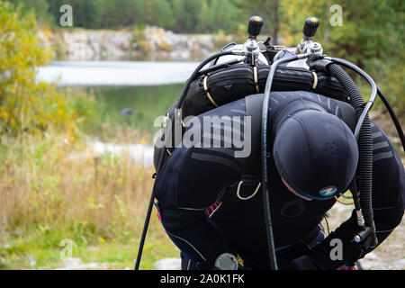 Paayanne See, Finnland - September 2019. Diver prüft Geräte in der Nähe des Sees. Männliche Taucher im Neoprenanzug überprüfen Ausrüstungen vor dem Eintauchen. Stockfoto