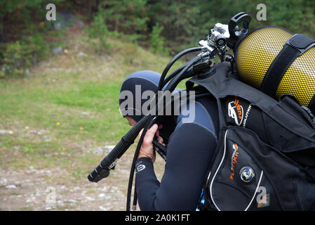 Paayanne See, Finnland - September 2019. Diver prüft Geräte in der Nähe des Sees. Männliche Taucher im Neoprenanzug überprüfen Ausrüstungen vor dem Eintauchen. Stockfoto