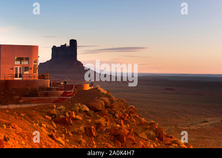 Touristen stehen auf der Terrasse im Freien des Fotografen in der View Hotel mit Blick auf die Mitten Buttes im Monument Valley Tribal Park bei Sonnenuntergang, Mo Stockfoto