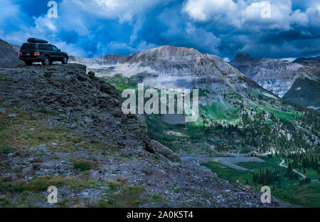 Jeep mit einem Gepäckträger auf dem Fahrzeug befindet sich auf einer Klippe mit Blick auf einen gefährlich steilen Abgrund auf einem Pass in Ouray, Colorado, USA Stockfoto