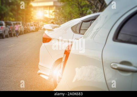 Weißes Auto auf der Straße geparkt und Sonnenlicht auf Hintergrund, Licht von der Rückseite Auto Stockfoto