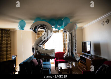 Glänzendes Silber und Blau 21. Geburtstag Luftballons hängen von Zimmer Decke Stockfoto