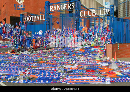 Glasgow, UK. 20 Sep, 2019. Tribute, einschließlich Blumen, Schals, Fußball, Karten und Kuchen haben an der Broomloan Straße und Copland Straße Tore von Ibrox Stadion, der Heimat der Glasgow Rangers in Respekt für FERNANDO RICKSEN, der Niederländischen internationalen Fußballer, die für Förster und der starb der Motor Neuron Disease (MND) am 18. September 2019, im Alter von 43 Links. Credit: Findlay/Alamy leben Nachrichten Stockfoto