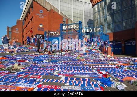 Glasgow, UK. 20 Sep, 2019. Tribute, einschließlich Blumen, Schals, Fußball, Karten und Kuchen haben an der Broomloan Straße und Copland Straße Tore von Ibrox Stadion, der Heimat der Glasgow Rangers in Respekt für FERNANDO RICKSEN, der Niederländischen internationalen Fußballer, die für Förster und der starb der Motor Neuron Disease (MND) am 18. September 2019, im Alter von 43 Links. Credit: Findlay/Alamy leben Nachrichten Stockfoto