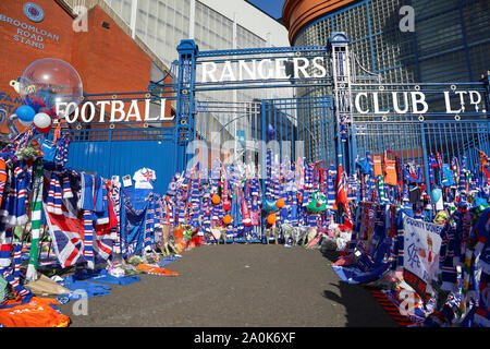 Glasgow, UK. 20 Sep, 2019. Tribute, einschließlich Blumen, Schals, Fußball, Karten und Kuchen haben an der Broomloan Straße und Copland Straße Tore von Ibrox Stadion, der Heimat der Glasgow Rangers in Respekt für FERNANDO RICKSEN, der Niederländischen internationalen Fußballer, die für Förster und der starb der Motor Neuron Disease (MND) am 18. September 2019, im Alter von 43 Links. Credit: Findlay/Alamy leben Nachrichten Stockfoto