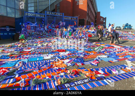 Glasgow, UK. 20 Sep, 2019. Tribute, einschließlich Blumen, Schals, Fußball, Karten und Kuchen haben an der Broomloan Straße und Copland Straße Tore von Ibrox Stadion, der Heimat der Glasgow Rangers in Respekt für FERNANDO RICKSEN, der Niederländischen internationalen Fußballer, die für Förster und der starb der Motor Neuron Disease (MND) am 18. September 2019, im Alter von 43 Links. Credit: Findlay/Alamy leben Nachrichten Stockfoto