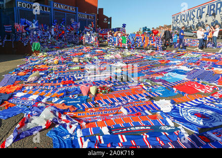 Glasgow, UK. 20 Sep, 2019. Tribute, einschließlich Blumen, Schals, Fußball, Karten und Kuchen haben an der Broomloan Straße und Copland Straße Tore von Ibrox Stadion, der Heimat der Glasgow Rangers in Respekt für FERNANDO RICKSEN, der Niederländischen internationalen Fußballer, die für Förster und der starb der Motor Neuron Disease (MND) am 18. September 2019, im Alter von 43 Links. Credit: Findlay/Alamy leben Nachrichten Stockfoto