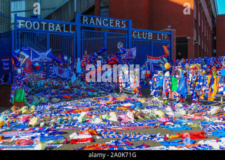 Glasgow, UK. 20 Sep, 2019. Tribute, einschließlich Blumen, Schals, Fußball, Karten und Kuchen haben an der Broomloan Straße und Copland Straße Tore von Ibrox Stadion, der Heimat der Glasgow Rangers in Respekt für FERNANDO RICKSEN, der Niederländischen internationalen Fußballer, die für Förster und der starb der Motor Neuron Disease (MND) am 18. September 2019, im Alter von 43 Links. Credit: Findlay/Alamy leben Nachrichten Stockfoto