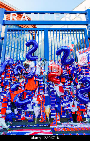 Glasgow, UK. 20 Sep, 2019. Tribute, einschließlich Blumen, Schals, Fußball, Karten und Kuchen haben an der Broomloan Straße und Copland Straße Tore von Ibrox Stadion, der Heimat der Glasgow Rangers in Respekt für FERNANDO RICKSEN, der Niederländischen internationalen Fußballer, die für Förster und der starb der Motor Neuron Disease (MND) am 18. September 2019, im Alter von 43 Links. Credit: Findlay/Alamy leben Nachrichten Stockfoto