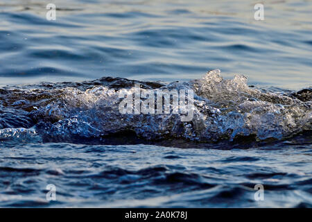 Eine Nahaufnahme Bild von einigen Wellen in die Ufer plätschern Einige Spritzer und Blasen erzeugen auf Vancouver Island British Columbia Kanada. Stockfoto