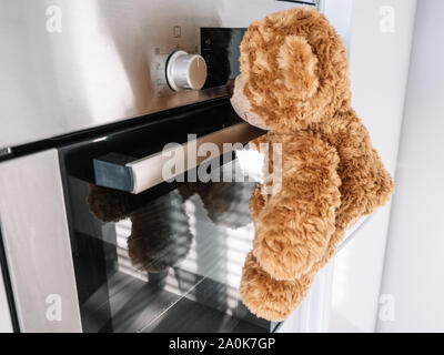 Brauner Teddybär, ist, wie sich der Backofen in der Küche geht Stockfoto