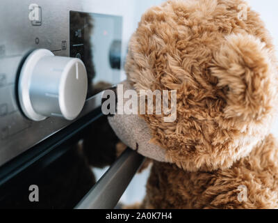 Brauner Teddybär, ist, wie sich der Backofen in der Küche geht Stockfoto