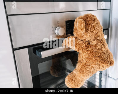 Brauner Teddybär, ist, wie sich der Backofen in der Küche geht Stockfoto