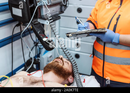 Arzt schreiben Ärztlicher Bericht in die Zwischenablage am Krankenhaus, Dringlichkeit. Medizin, Menschen und medizinisches Konzept. Stockfoto