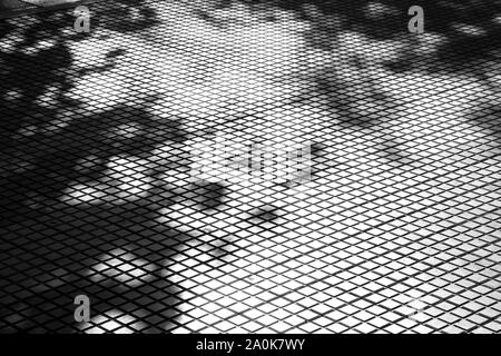 Schatten von Bäumen auf Fliesen- stadt Bürgersteig, abstrakten architektonischen Hintergrund in hoher Kontrast schwarz und weiß Stockfoto