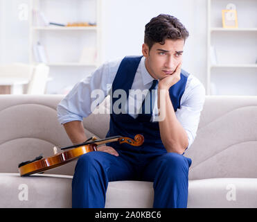Der junge Musiker Mann spielen Geige Üben zu Hause Stockfoto
