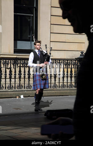 Glasgow Schottland Buchanan Street Dudelsackpfeifer Straßenmusik-Mann mit Handy in der Hand Stockfoto