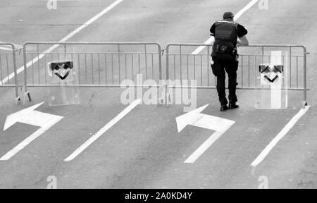 Belgrad, Serbien - September 15, 2019: ein Polizist und zwei Schilde auf vorübergehende Absperrung Zaun auf Straße der Stadt lehnte, von hinten in Schwarz und Whi Stockfoto