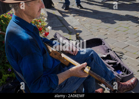 Straßenmusiker spielen 1930 akustischen Blues aus einer Gitarre aus einer zigarrenkiste an der Brunnen Marktplatz, Brunnen, Somerset, UK Stockfoto