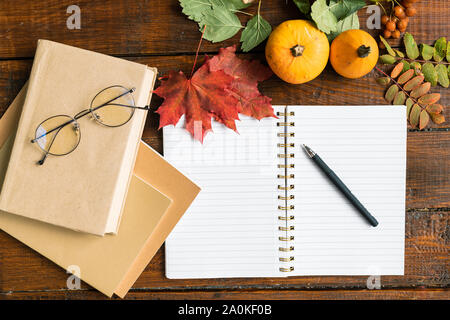 Copybook mit pen Öffnen, Bücher mit Brillen, Kürbisse und Blätter im Herbst Stockfoto
