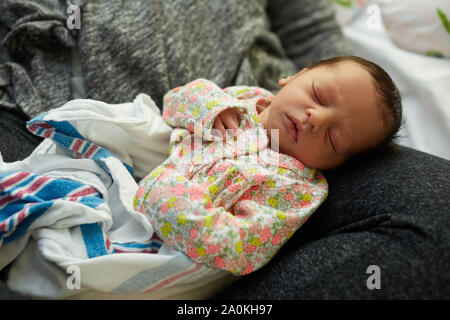 Neugeborenes Mädchen in der Mutter Schoß Schlafen im Krankenhaus