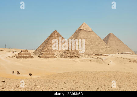 Touristen auf Kamele sehen Khufu, Khafre, Menkaure und Pyramiden von Königinnen aus Wüste. Stockfoto