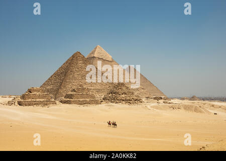 Touristen auf Kamele sehen Khufu, Khafre, Menkaure und Pyramiden von Königinnen aus Wüste. Stockfoto