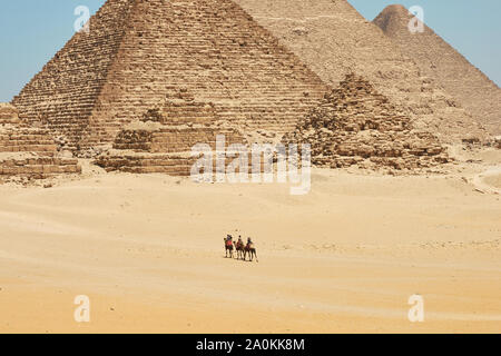 Touristen auf Kamele sehen Khufu, Khafre, Menkaure und Pyramiden von Königinnen aus Wüste. Stockfoto