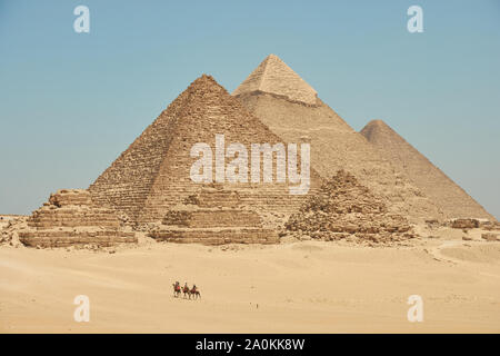 Touristen auf Kamele sehen Khufu, Khafre, Menkaure und Pyramiden von Königinnen aus Wüste. Stockfoto