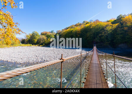 Die Hängebrücke über die Mountain River Foto. Stockfoto