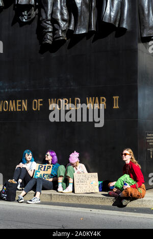 20. September 2019, London, UK - Junge Mädchen sitzt auf dem Boden durch das Denkmal für die Frauen des Zweiten Weltkriegs, die eine RIP-Zeichen der Erde auf das globale Klima Streik in Westminster Stockfoto