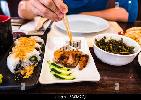 Verschiedene Gerichte der japanischen Küche, Shushi, lackierte Ente und Algensalat, serviert auf der Tabelle der ein asiatisches Restaurant. Stockfoto