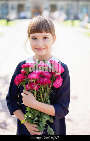 Blumenstrauß für geliebten Lehrer am ersten September. Blumen für die letzte Glocke. Tag des Wissens. Anfang des Schuljahres. Schulmädchen mit Blumenstrauß in s Stockfoto