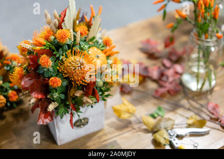 Prozess der Erstellung von Herbst Blumenstrauß aus gemischten Blumen auf Holztisch. Die Arbeit der Florist in einem Blumenladen. Frische Schnittblume. Stockfoto